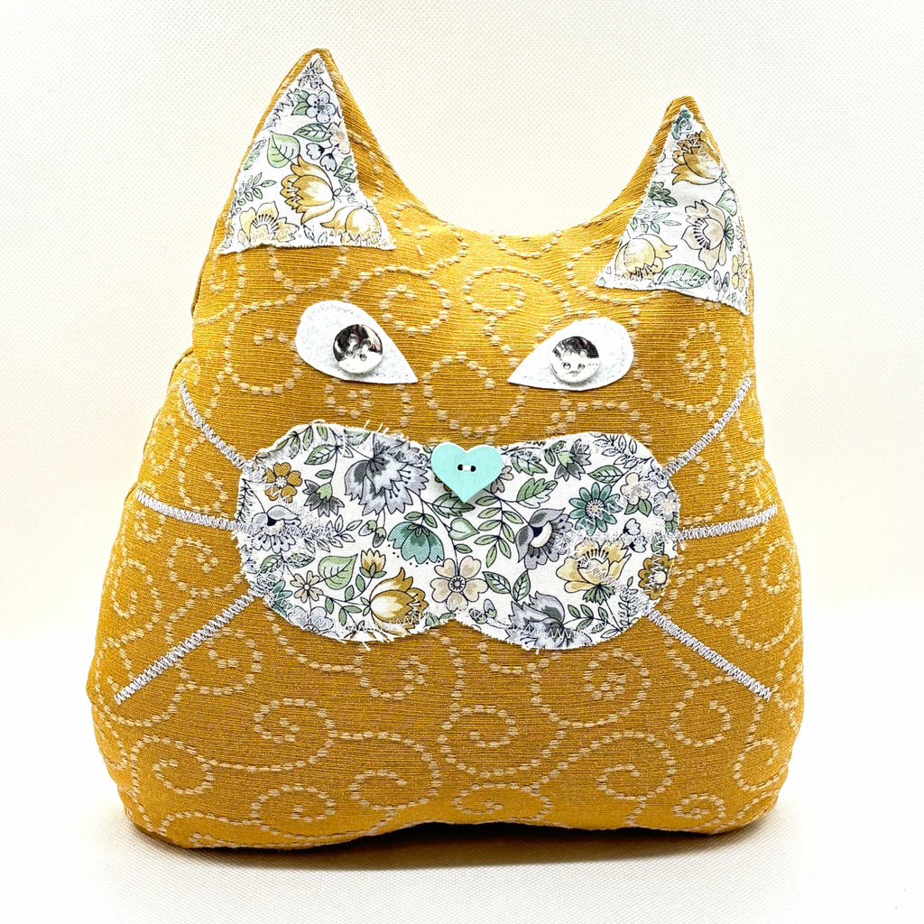 Tan cat doorstop with gray tan and mint green detail