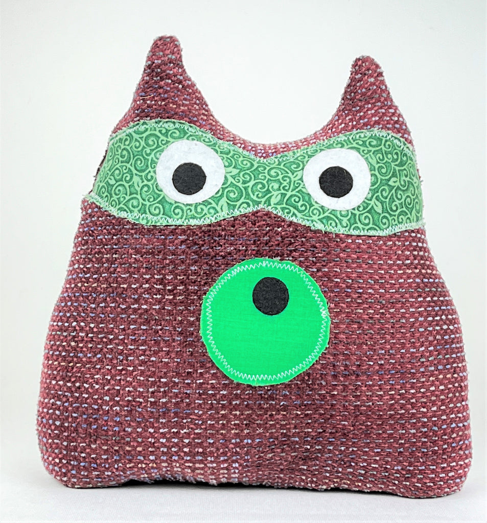 Maroon raccoon doorstop with green accents